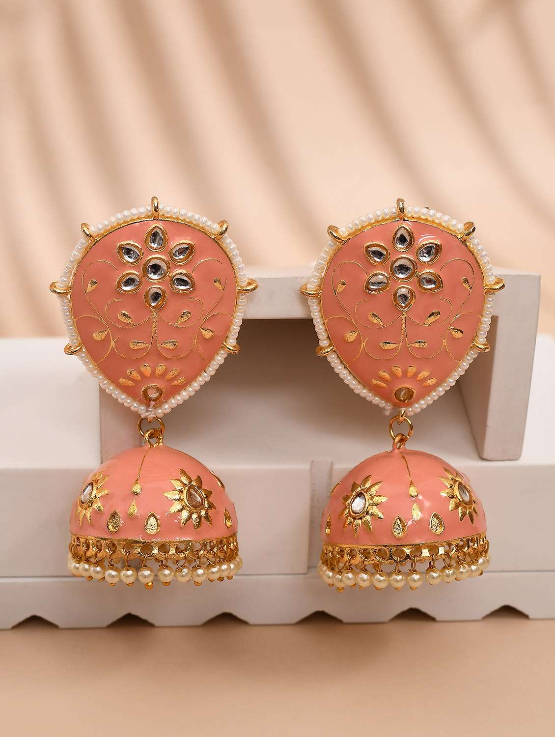 peach & gold-plated dome shaped kundan stone jhumkas earrings