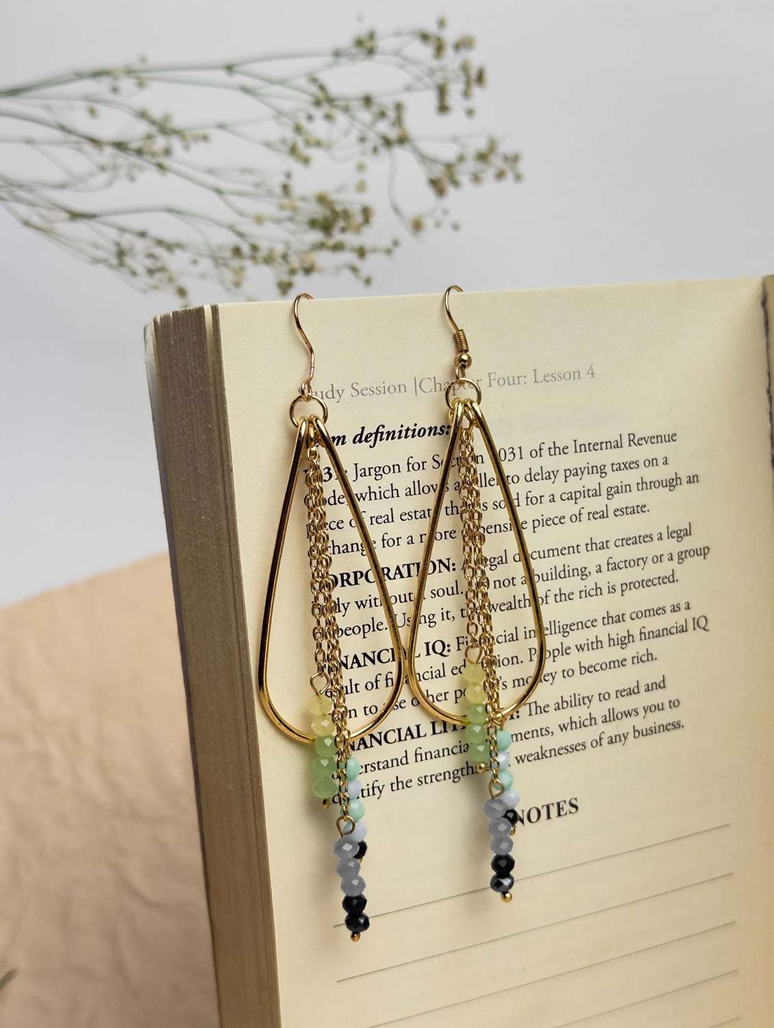 gold-toned metal teardrop earring with beaded tassels